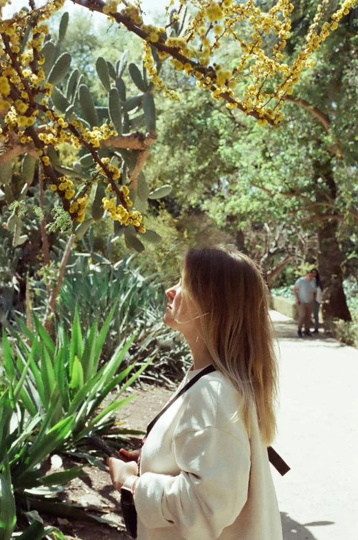 a woman standing outside in front of a plant