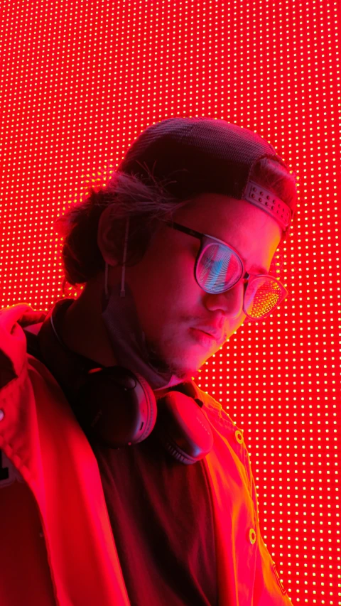 a man that has headphones on stands in front of a large pattern