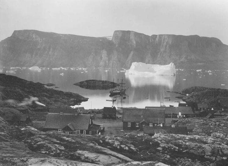 a mountain and sea with houses on the shore