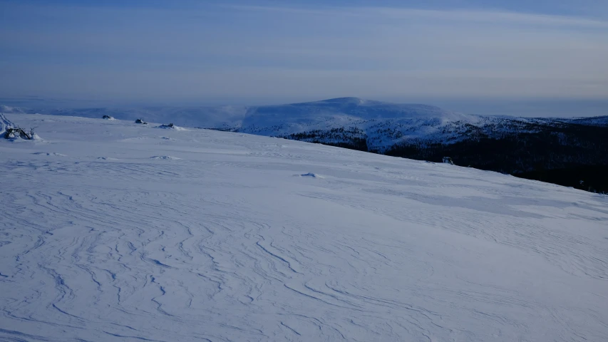 a single skier skiing down a snow covered mountain