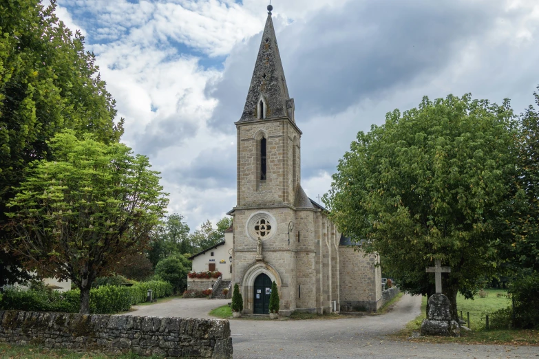 a church sits by the trees in a village