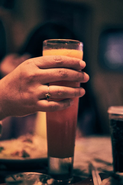 a woman holding her hand over a glass