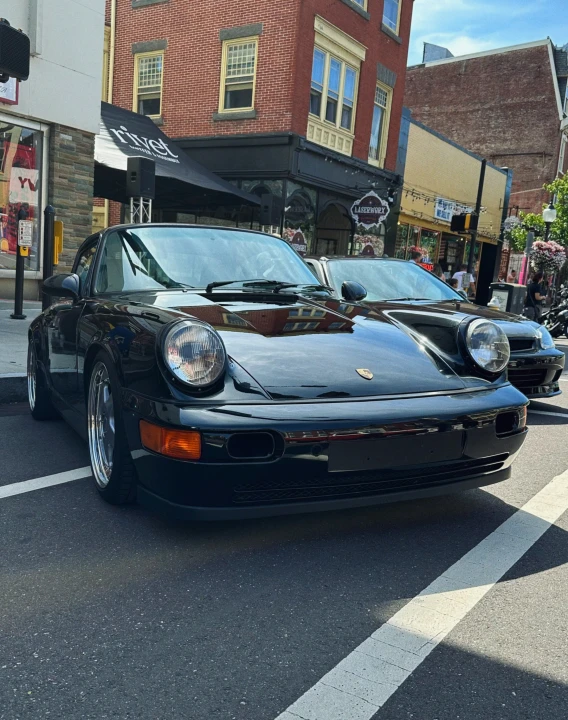 a porsche coupe sitting in the middle of the road