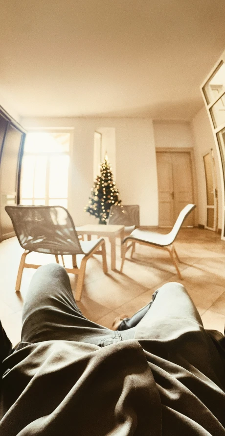 a man laying down in front of a christmas tree