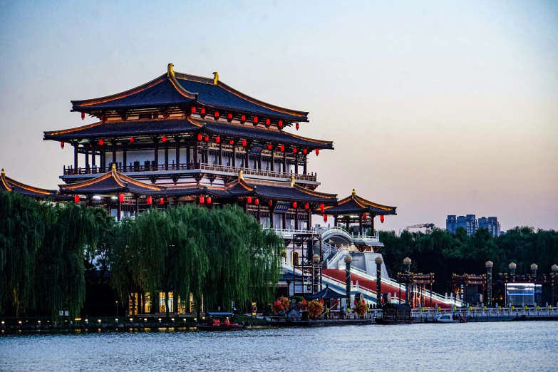 a tall tower next to the water at sunset