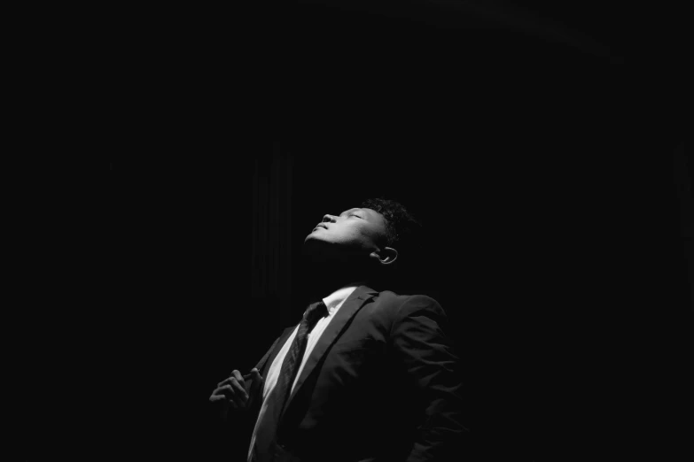 a black and white pograph of a man in a suit standing up