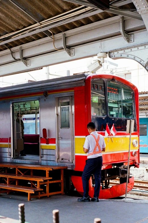 a man is standing outside a colorful train car