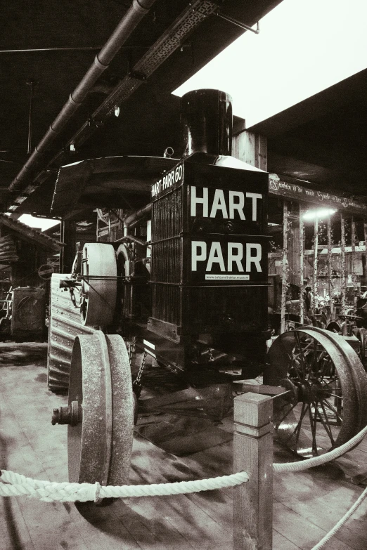 an exhibit with a locomotive, a cart, and people looking at it