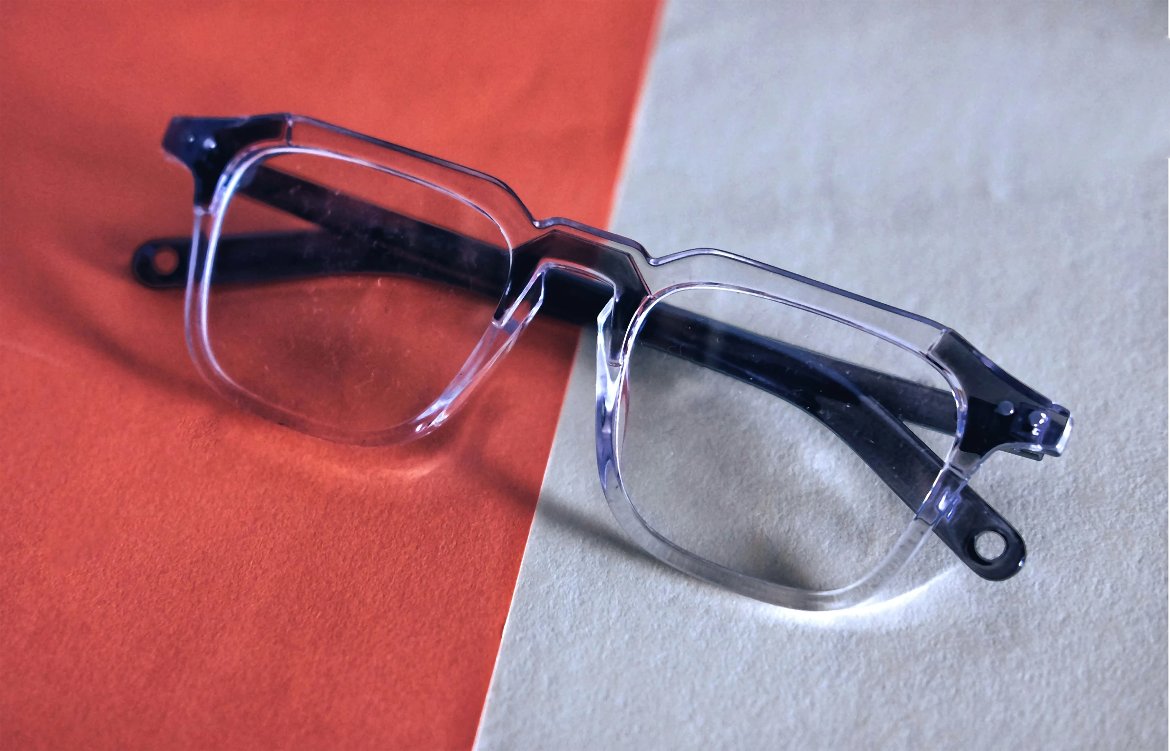 a pair of eyeglasses resting against a red and white background