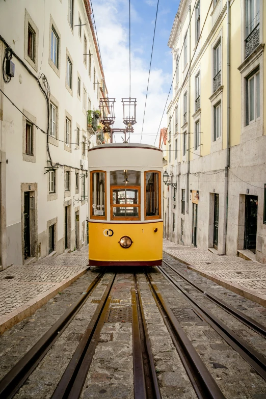 the yellow tram is on the tracks through the old city