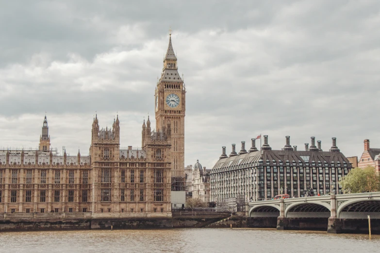 a large brown clock tower is over water