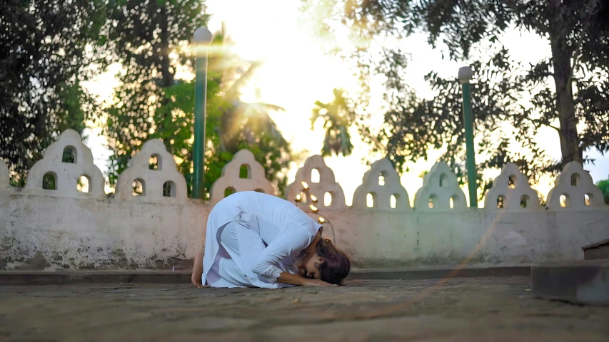 woman kneeling down on street with her head against wall