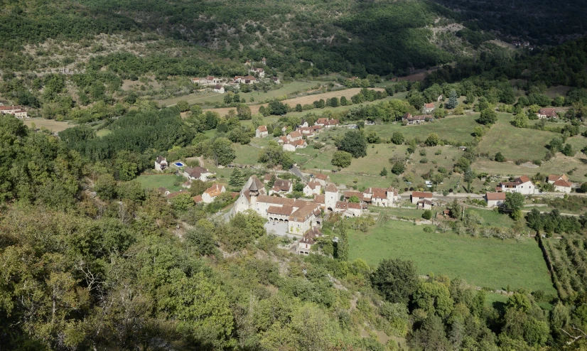 the valley where the houses are situated, is surrounded by trees and mountains