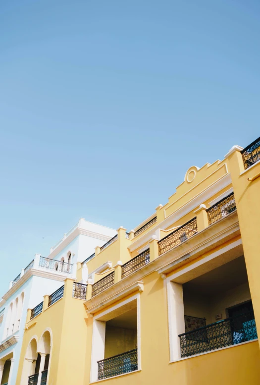 the outside of a yellow building with balconies