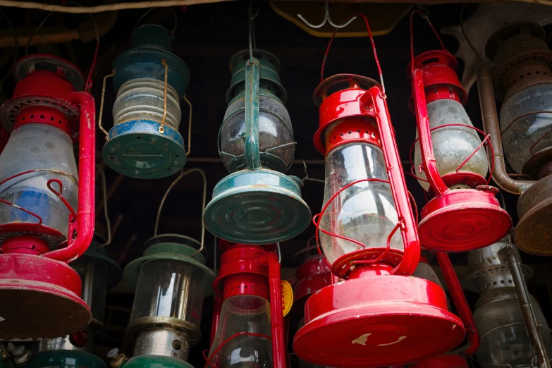 some colored metal lanterns are hanging from a wire