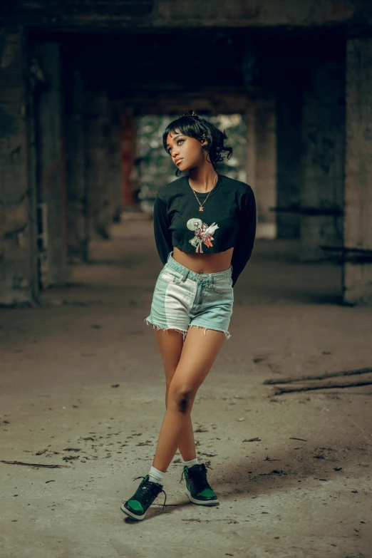 a woman is posing in shorts and boots