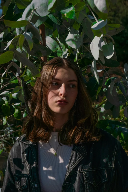 a woman is posing for the camera under a tree