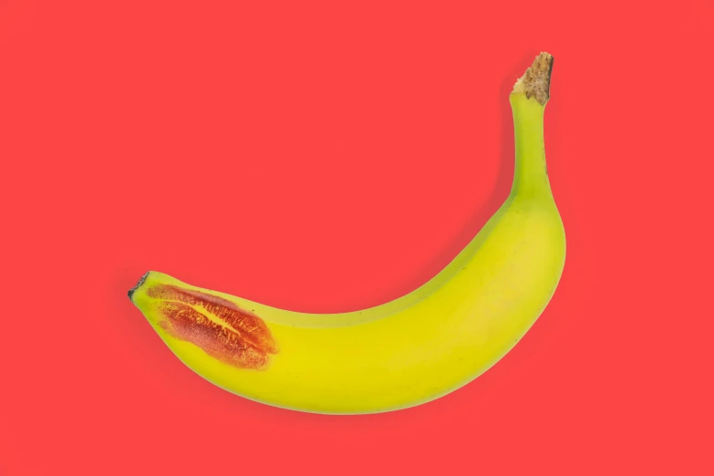 a yellow banana with yellow and red highlights on its side