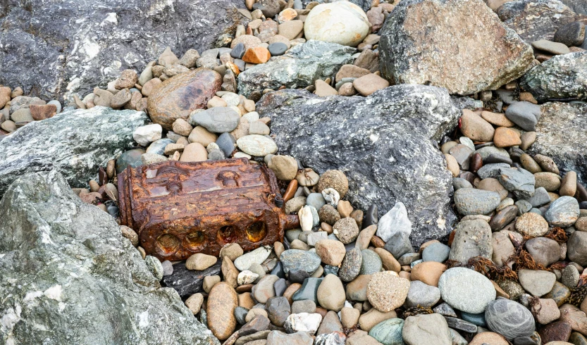 a rock covered field with some kind of red thing laying on it