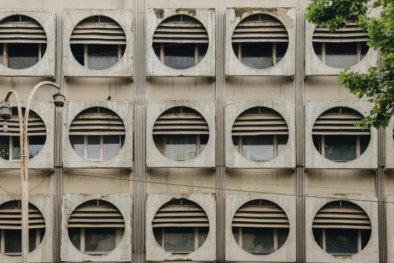 the side of a building is covered with circles and windows