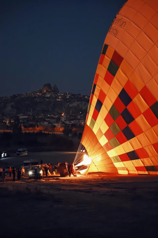 several people standing around and watching a big  air balloon