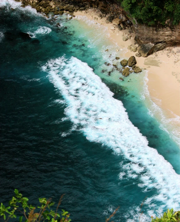 an ocean view looking down at a sandy beach