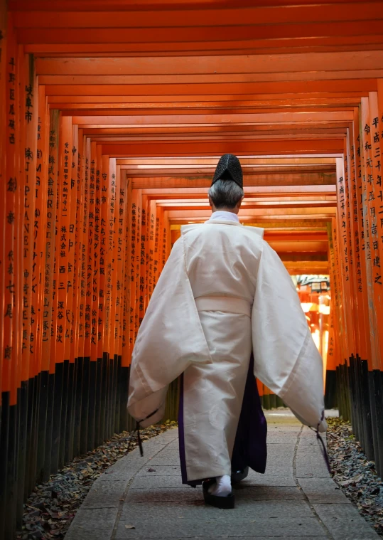 a man walking through an orange and black archway