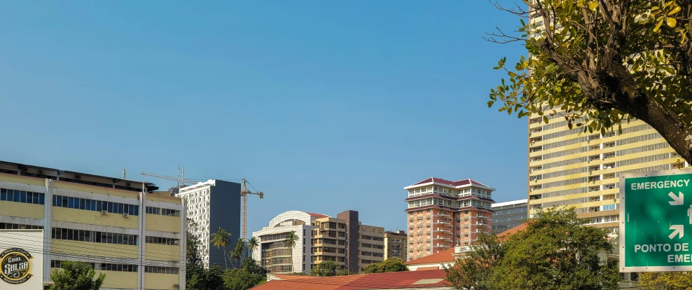 city traffic signs on a highway with tall buildings in the background