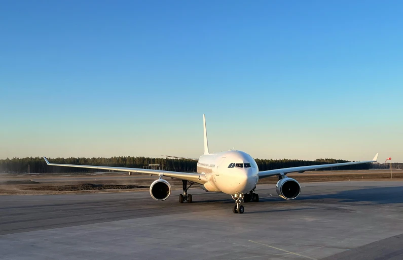 the white plane is parked on the runway