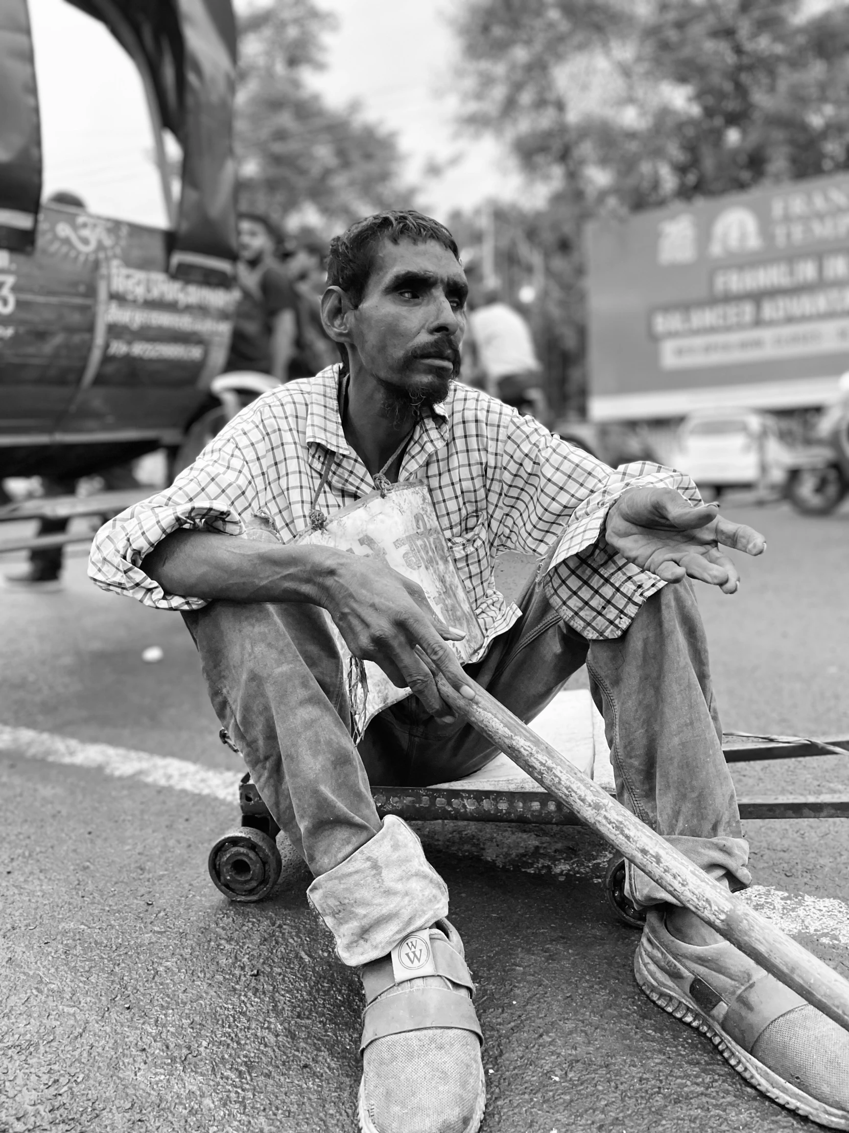 a man is sitting with a baseball bat on a street