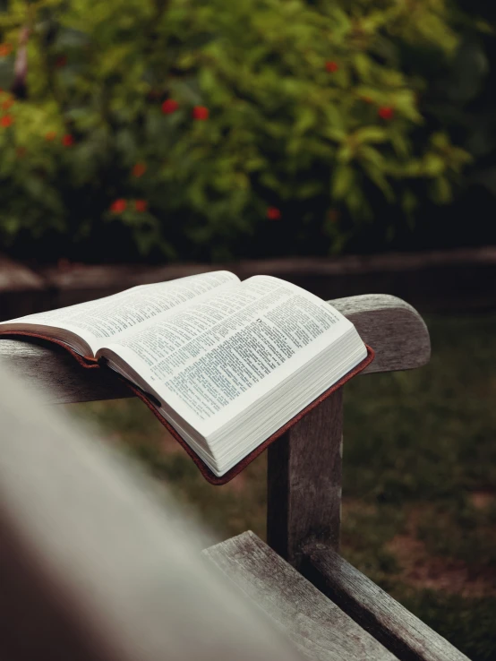 an open book sits on top of a bench