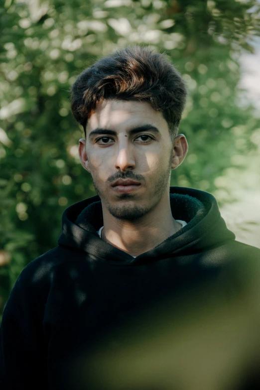 a man with a hoodie looking into the camera