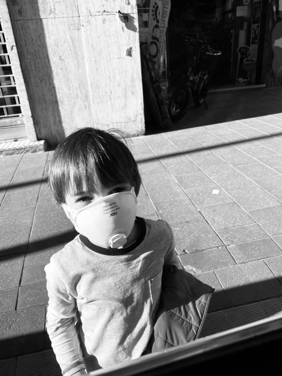 the little boy wears a face mask with the help of a breathing tube