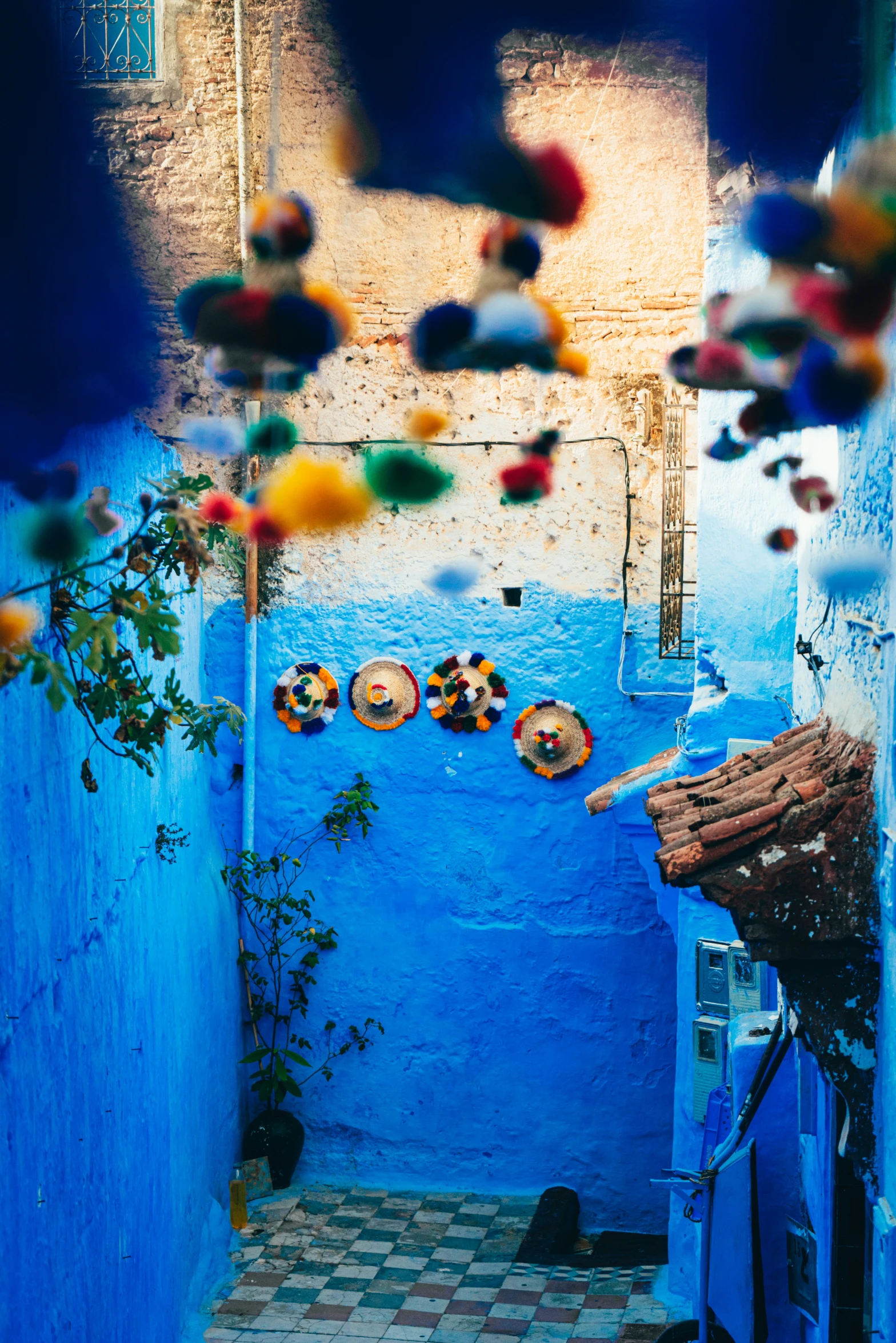 a room with blue walls, a tile floor and decorative ornaments hanging from the ceiling