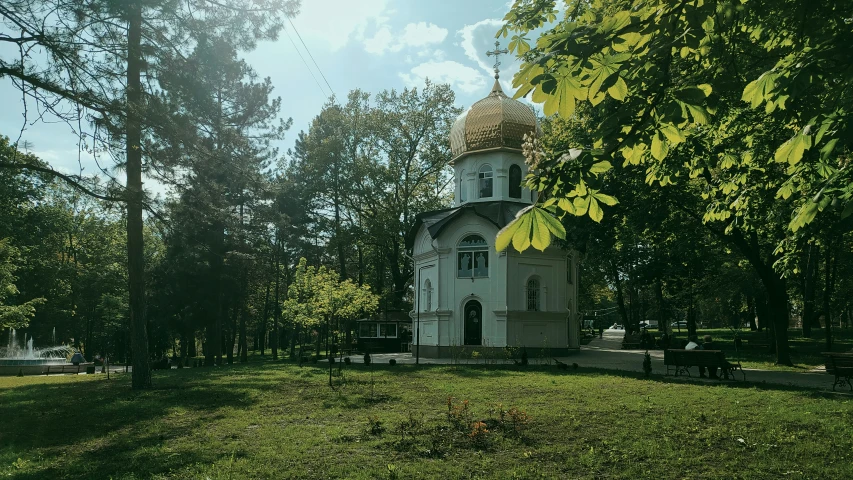 there is a white church surrounded by trees and shrubs