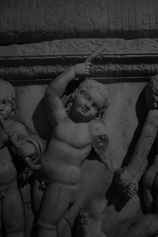 a stone sculpture of four cherubs holding hands