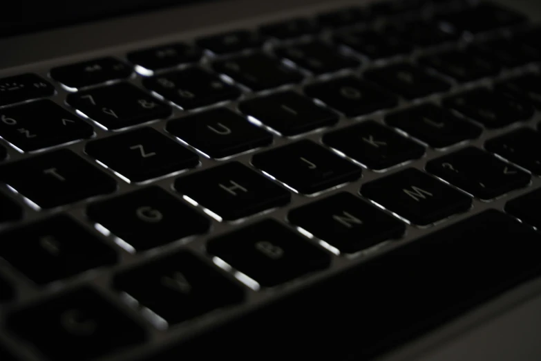 a black keyboard with illuminated words sits on a table