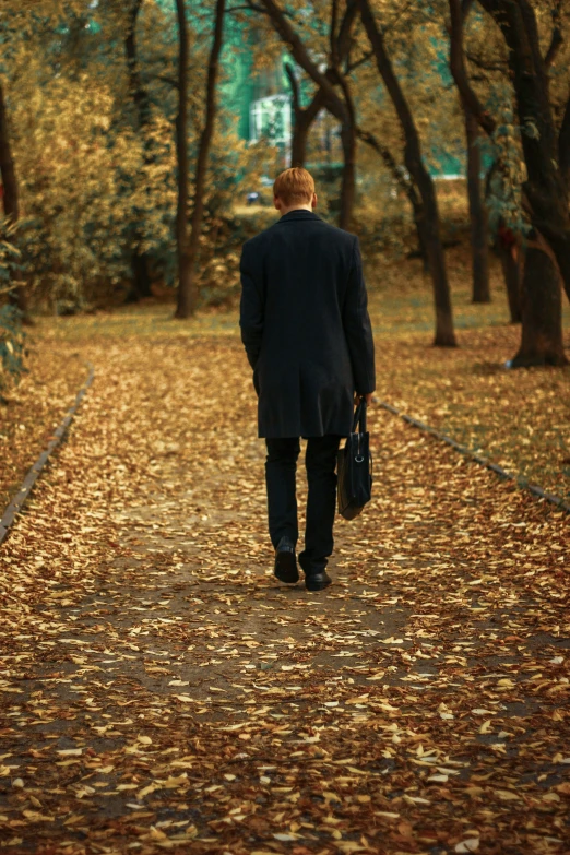 a man is walking on the road in the park