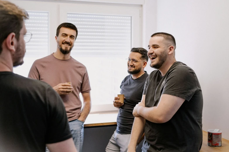 four men smiling and laughing in a room