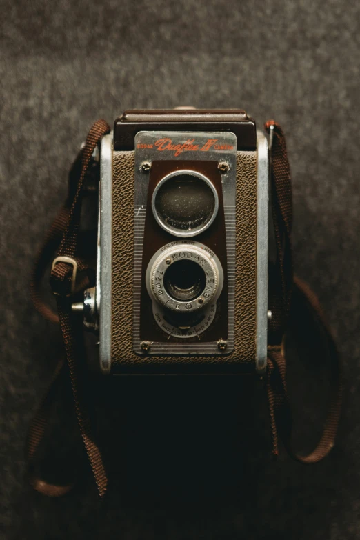 a camera is shown with a brown strap