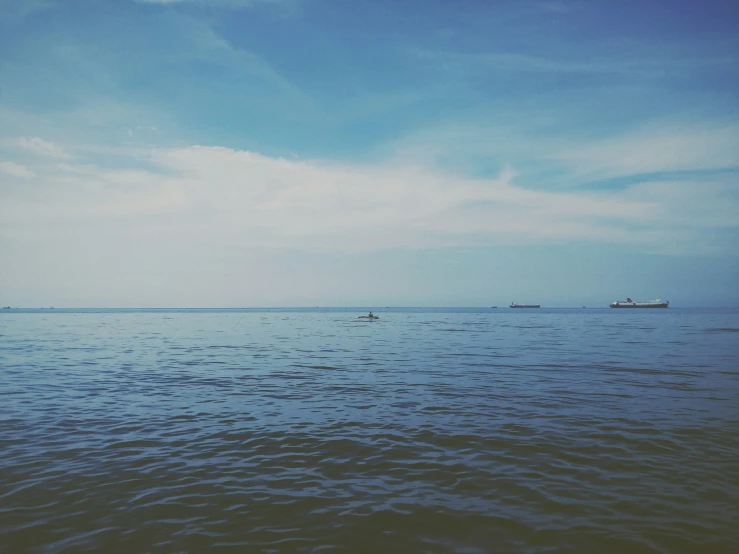 a very wide body of water with some boats on the horizon