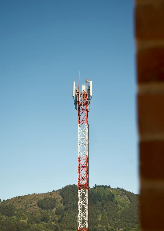 a mobile phone tower in a park on a sunny day