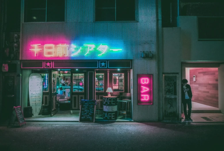 a shop front with neon lights in a darkened lit building