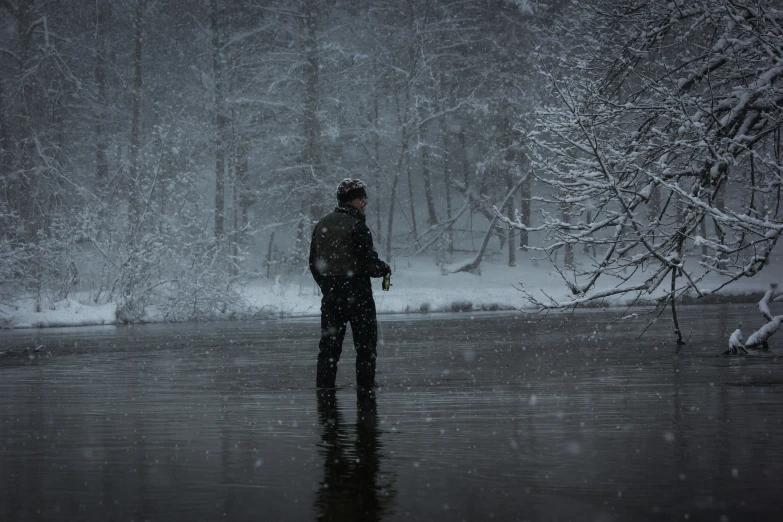 a man standing in the water under an umbrella