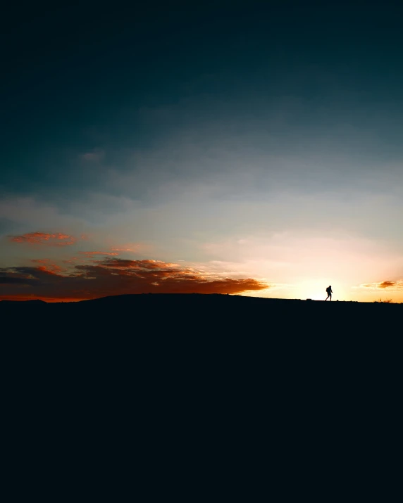 the person is standing on a hill at dusk