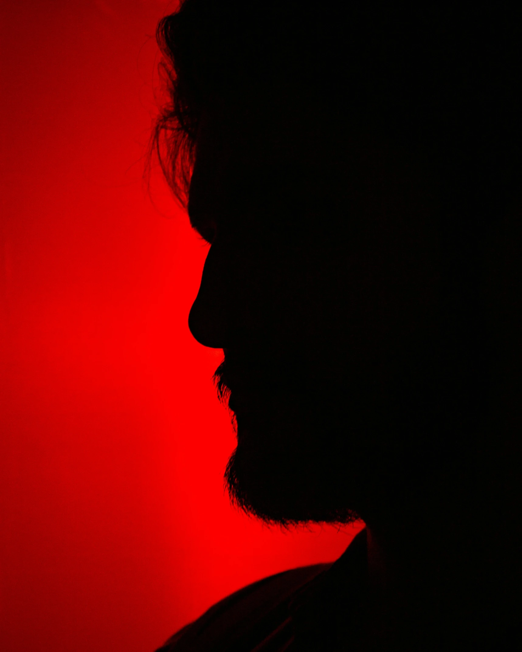 the person is silhouetted against the red background