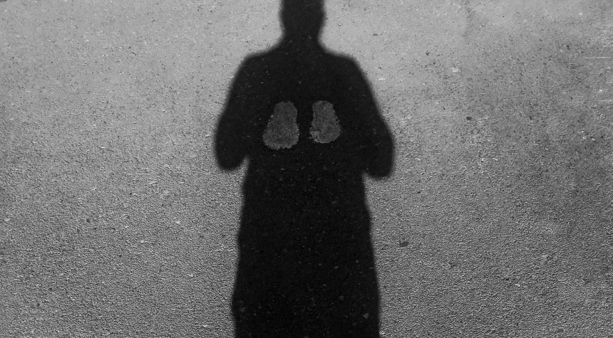 a person casting a shadow with their shoes on