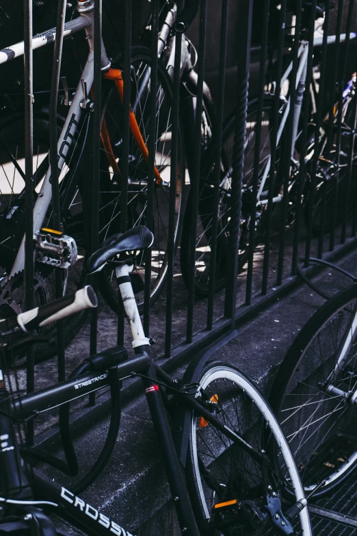 many bikes are parked together behind black metal fences