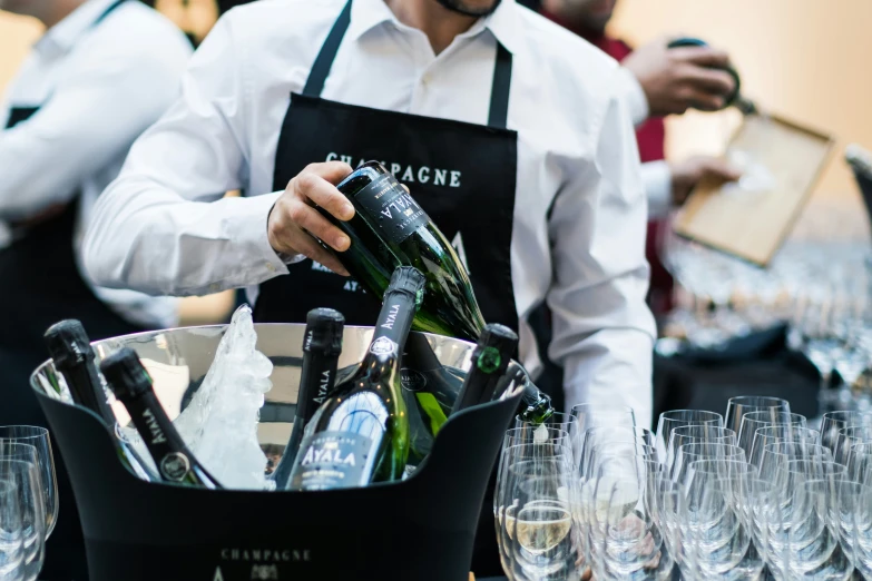 wine glass bottles and champagne in buckets while people observe