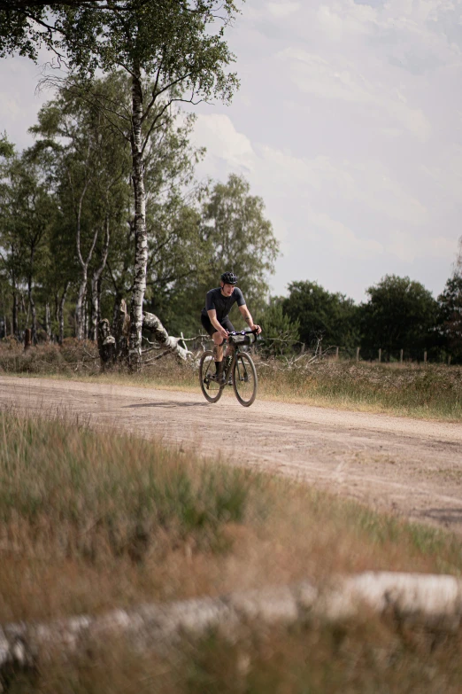 a person riding a bicycle down a dirt road